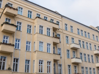 Fototapeta na wymiar Yellow Apartment Building with Small Balconies