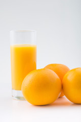 Oranges and glassful of fruit juice.