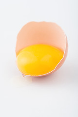 Half of egg with running yolk on the surface.