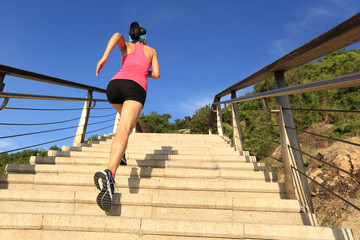 young fitness woman runner running on seaside stone stairs