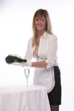 Waitress in sexy uniform pouring a glss of sparkling wine