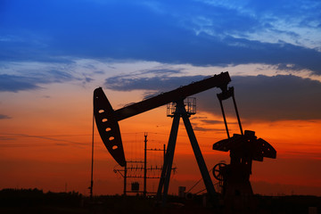 Oil field scene, the evening of beam pumping unit in silhouette