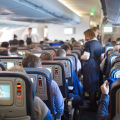 Obraz premium Stewardessand passengers on commercial airplane.