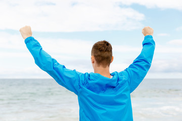 Young man in sport wear with outstretched arms