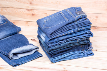 Piles of jeans on wooden background