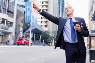 Businessman catching taxi in city