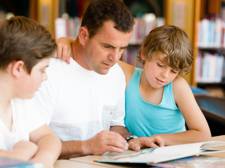 Father with sons in library