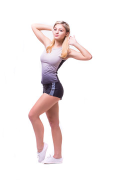 Attractive fit woman exercising in studio with copyspace. Image of healthy young female athlete doing fitness workout against grey background.