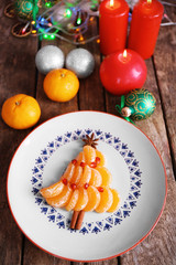Christmas fir tree made from tangerines, on plate, close up