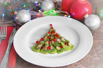 Christmas fir tree made from kiwi, on plate, close up