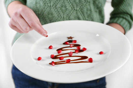 Woman holding plate with Christmas fir tree made from chocolate