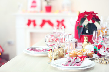 Christmas table setting with holiday decorations on fireplace background