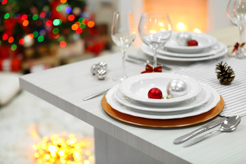 Christmas table setting with holiday decorations on fireplace background