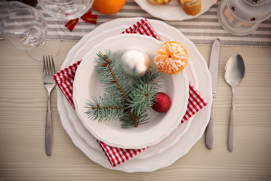 White plates with flatware on a Christmas table