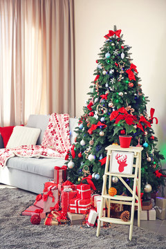 Christmas fir tree with gifts in living room