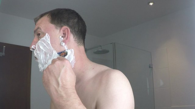Mann rasiert sich das Gesicht