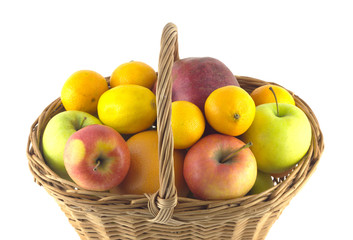 Brown wicker basket full of ripe fruits isolated on white closeup