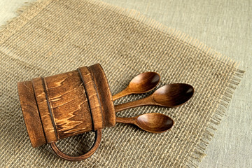 Wooden spoons. 
 Wooden spoons in a wooden mug on sackcloth.
  