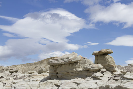 Lenticular clouds over rock formations in desert of La Leona Petrified Forest, Patagonia, Argentina.