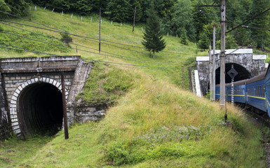 Two tunnels in the Carpathians with entering train
