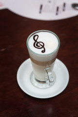 cup of latte with a treble clef on the table
