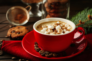 Mug of hot chocolate with marshmallows, fir tree branch on wooden background