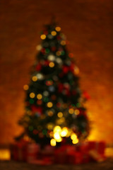 Blurred Christmas tree with presents on brick wall background