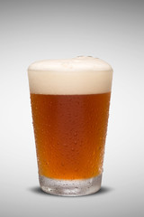 Glass of fresh beer with cap of foam isolated on white backgroun