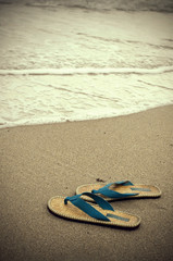 Fototapeta na wymiar Vintage Looking Sepia Sandals and Ocean Water