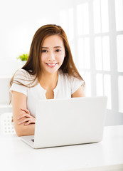 happy young woman with laptop in living room
