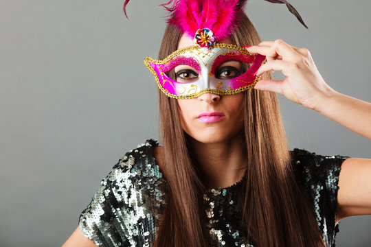 woman face with carnival mask on gray
