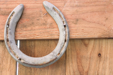 old rusty horseshoe on vintage wooden board