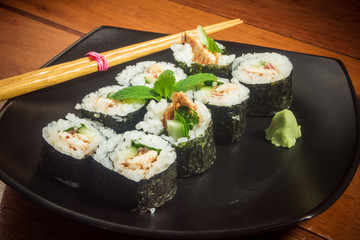 Japanese roll with chicken and cucmber on the black plate