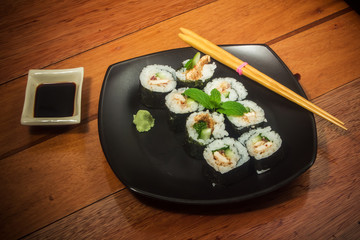 Japanese roll with chicken and cucmber on the black plate