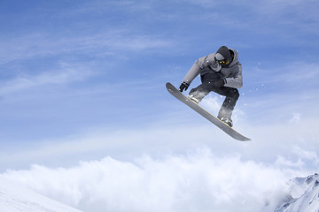 Flying snowboarder on mountains. Extreme sport.