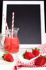 Fresh delicious strawberry smoothie with black board for message 