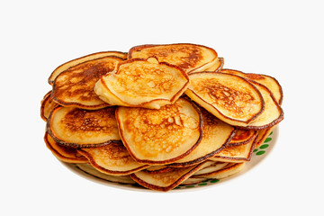 Delicious fried pancakes lie in a heap. Isolated on white background