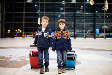 Two cute little sibling children, boys, at the airport, travelin