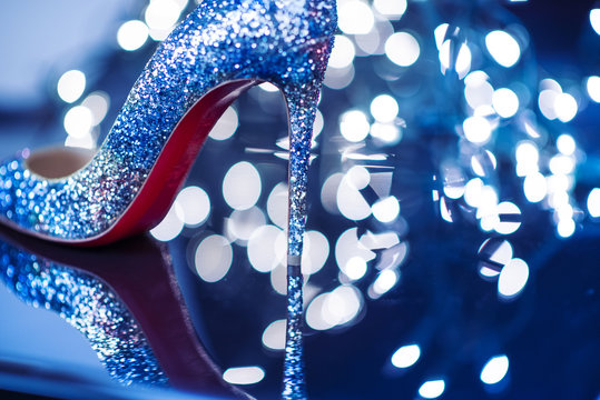 Diamonds shining high heels red bottom in blue mirror