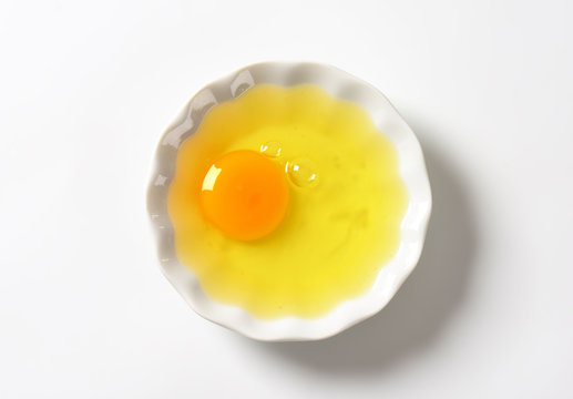 Raw egg white and yolk in bowl