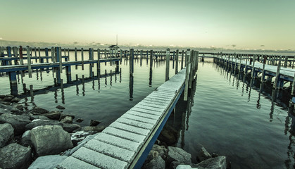 Fototapeta premium Lake Huron Gray. Snow falls on an abandoned marina as winter settles in over the coast of Lake Huron.