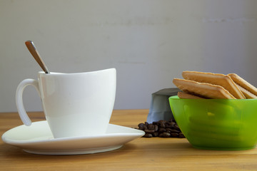 cup on saucer and biscuits