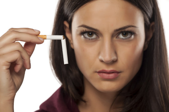 serious young woman holding a broken cigarette