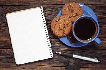 Blue cup of coffee, cookies and notepad