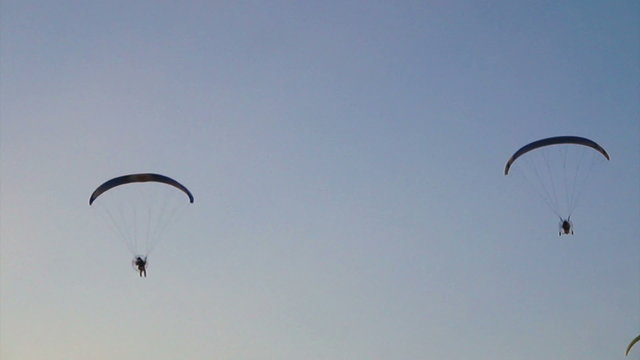 Telephoto shot of a paramotoring soaring over river in Thailand