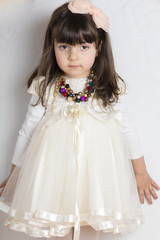 Studio shot of small girl in off white bride dress 