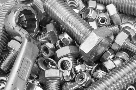 Industrial strong steel nuts bolts and washers mixture with a spanner tool / A mixture of strong steel nuts bolts and washers with a spanner tool
