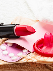Pills condom and lipstick on lace lingerie
