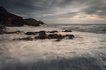 Sea foam covered Bracelet Bay on the Gower peninsula, Swansea