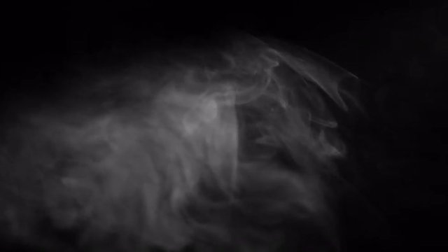 Smoky fog rises up into a beam of light.  Recorded against a black background and intended as a stand alone shot or for compositing using a blending mode.  Looping clip.
